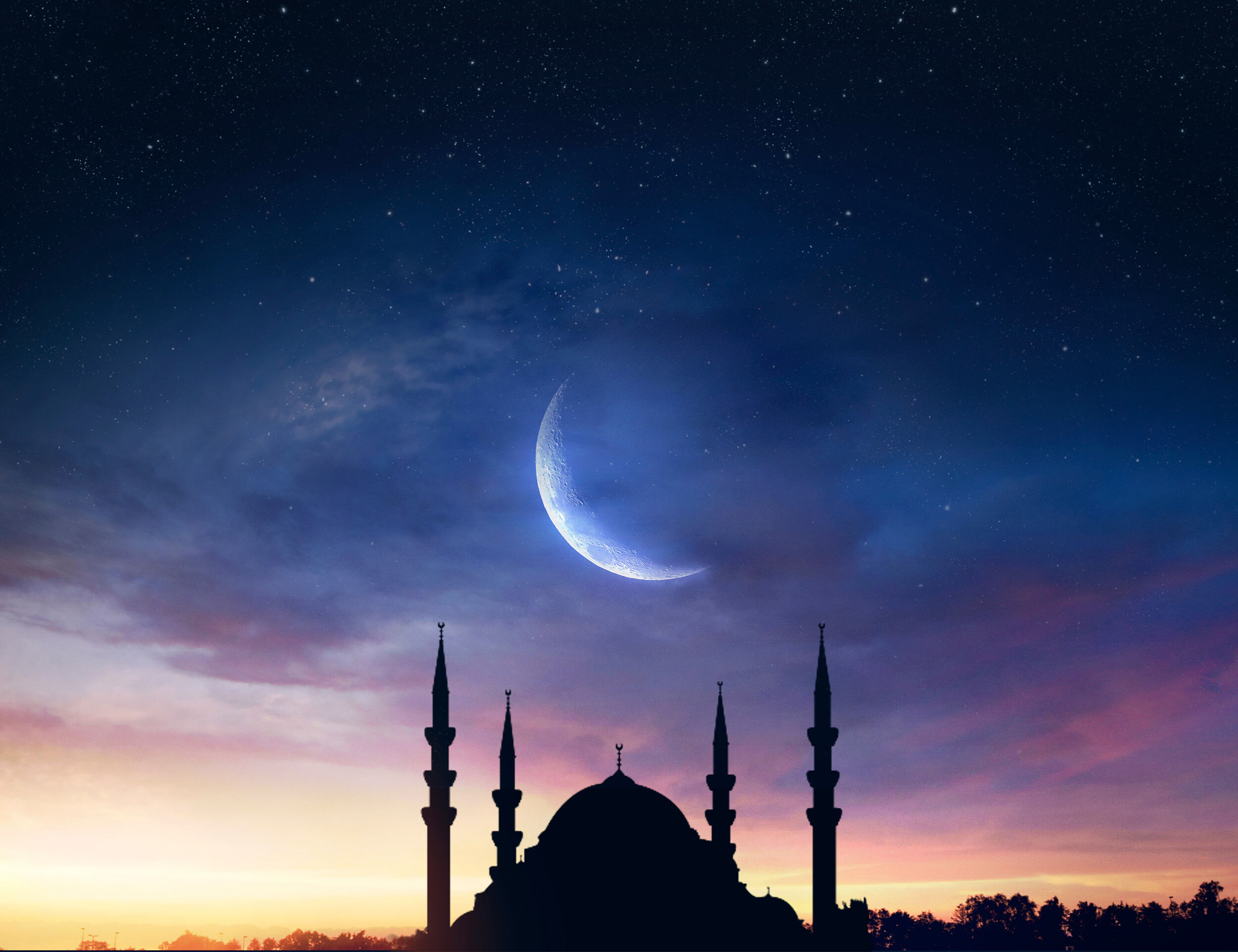 Silhouette of a mosque under a crescent moon and twilight sky, symbolizing Ramadan and Eid celebrations